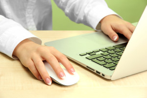 female hands writing on laptot, on green background